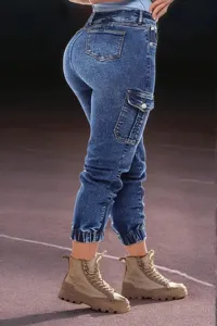 Detail view of women's blue elastic slim-fit denim cargo pants featuring cuffed ankles.