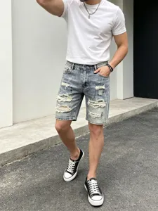 Men's summer high street distressed denim shorts with light wash and paint splatter design.