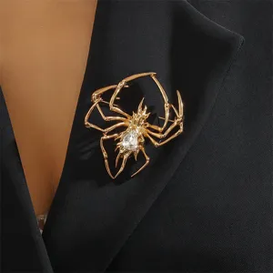 Nahaufnahme einer eleganten goldfarbenen Metallspinnenbrosche mit funkelndem Strassstein.