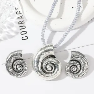 Silver nautilus shell pendant necklace and matching earrings set, ideal for beach vacation.