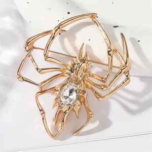 Detaillierte Nahaufnahme einer goldenen Spinnenbrosche mit glitzerndem Schmuckstein.