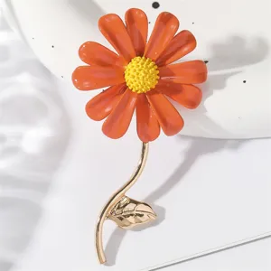Nahaufnahme einer orangefarbenen Emaille-Gänseblümchen-Brosche mit goldenem Stiel, filigran.