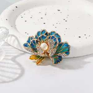 Detail shot of exquisite blue enamel peony brooch featuring sparkling rhinestones and center pearl accent.