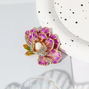 Detailed shot of a purple enamel peony brooch with central pearl and sparkling rhinestones.