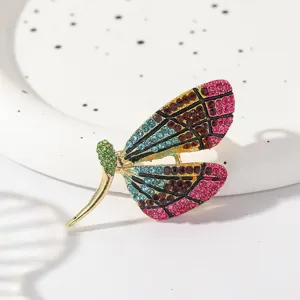 Close-up detail of a colorful rhinestone dragonfly brooch, alloy enamel lapel pin.