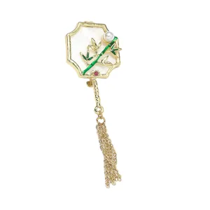 Exquisite Chinese style fan brooch detail with green bamboo enamel, pearl, and gold tassel.