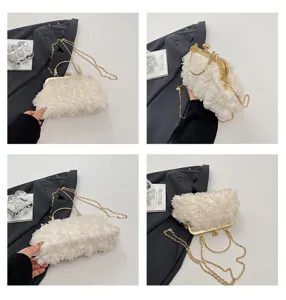Squisito dettaglio di borsa da sera con fiori 3D, montatura in metallo dorato e catena.