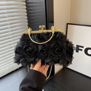 Dettaglio della borsa da sera con rose in rete nera e chiusura a bacio in metallo dorato.