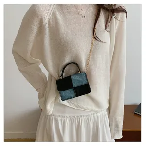 Close-up of the trendy contrast denim patchwork mini shoulder bag with gold chain strap detail.