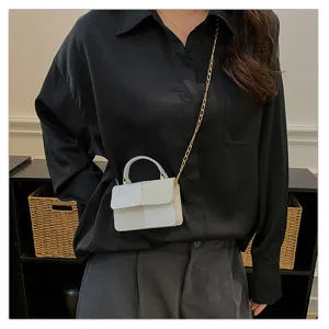 Detail view of the trendy color-block small square bag featuring chic gold chain and handle.