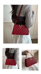 Detail en gros plan du sac a main rouge en strass dore avec logo V et fine laniere.