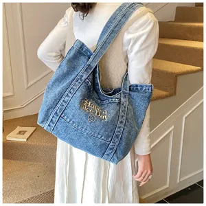 Gedetailleerd overzicht van casual denim tote bag met geborduurde slogan en ruim ontwerp.