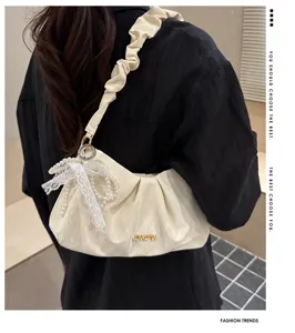 Close-up detail of the ruched shoulder cloud bag with pearl lace bow and metal logo.