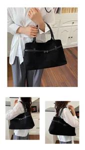 Detailed shot of black suede tote bag with belt detail, showing daily casual style and capacity.