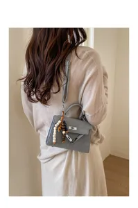 Gray top handle crossbody bag for women, elegant Kelly style small square bag with charms.