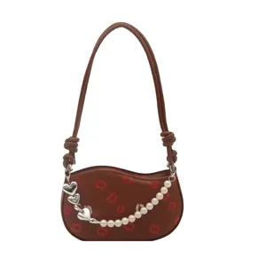 Sac d'épaule marron pour femme avec imprimé lèvres, chaîne en perles et breloques cœur.