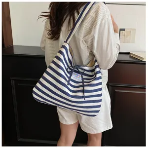 French style striped canvas shoulder bag detail view with cute bow and branded label.