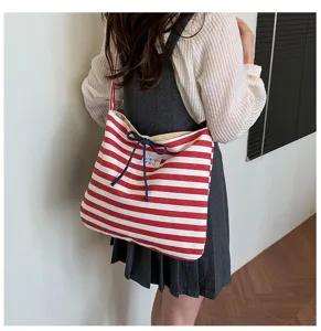 Red and white striped canvas shoulder bag with cute blue bow detail and custom label design.