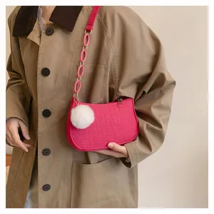 Detailansicht der stilvollen rosa Filz Baguette Schultertasche mit Kette und flauschigem Anhänger.