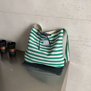 Green and white striped woven shoulder bag, stylish bow knot underarm handbag variant.