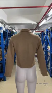 Detail view of women's retro solid color suede jacket back design in warehouse setting