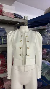 Veste blazer courte blanche pour femme avec boutons dorés élégants et manches bouffantes stylées.