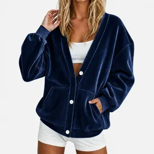 Close-up van dames donkerblauwe fluwelen V-hals vest met witte knopen en zachte stof.