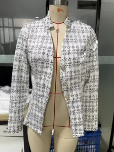 Detailed view of the women's black and white plaid print blazer jacket with gold buttons.