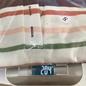 Detail view of a striped knitted long sleeve top in packaging, weighed at 204g, size S.