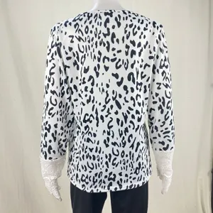 Back view of black and white leopard print long sleeve top with delicate lace cuff details.