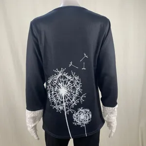 Women black long sleeve ribbed t-shirt with lace cuffs and white dandelion print detail view.