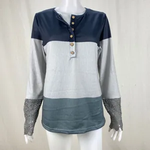 Detailed view of women long sleeve colorblock ribbed top with lace cuffs and wooden buttons.