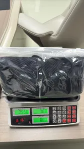 Vista dettagliata del cardigan nero in maglia collo V imballato sulla bilancia in magazzino.