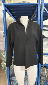 Detail view of a casual black waffle knit long sleeve top with deep V neck for women.
