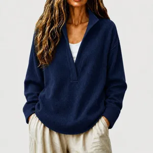 Close-up detail of the deep V-neck waffle knit sweater texture and sleeve cuff finish.