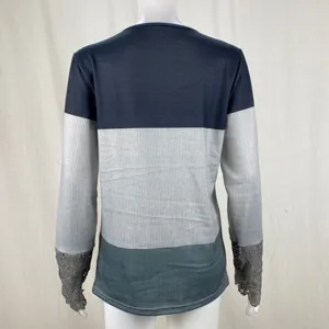 Back view of women long sleeve color block top with lace cuffs and ribbed knit texture detail.