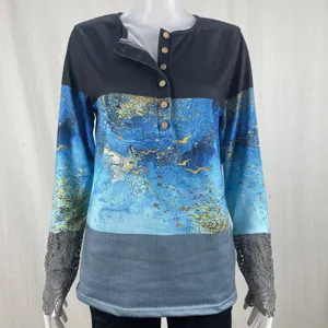 Detailed view of women's long sleeve colorblock top featuring elegant lace cuffs and buttons.