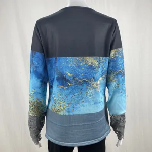 Back view detail of women long sleeve top with blue abstract print and lace cuffs design.