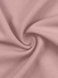 Fabric texture detail shot showing soft dusty pink material with natural spiral folds.