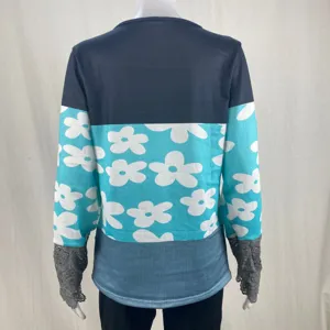 Details view of women's long sleeve colorblock floral t-shirt with elegant lace cuffs.