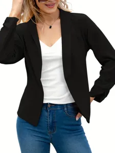 Detail view of a stylish black open-front blazer jacket paired with a white top and jeans.