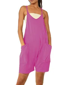 Close-up detail of the bright pink sleeveless romper with large side pockets and straps.