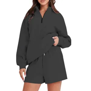 Dettagli della felpa grigia scura con mezza zip e pantaloncini, completo casual comodo.