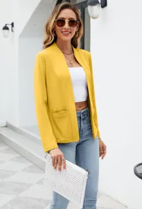 Dettaglio in primo piano della elegante giacca blazer gialla da donna con tasche.
