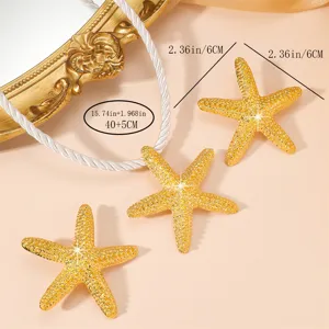 Gold starfish necklace and earrings set, beach resort vacation jewelry detail view.