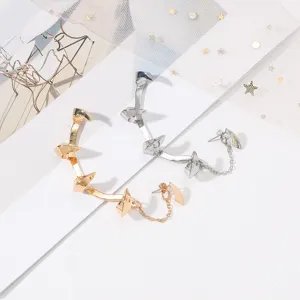 Nahaufnahme von Gothic Punk Teufelskralle Ohrklemmen in Gold und Silber mit Metallketten.
