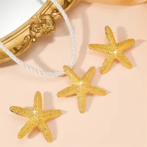 Close up of gold starfish jewelry details, sparkling ocean beach style marine theme design.