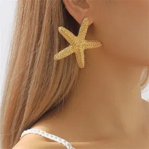 Exaggerated gold starfish stud earrings for women, ocean beach party fashion jewelry style.