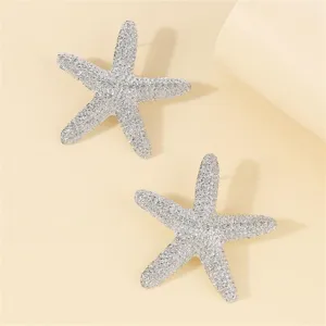 Sparkling rhinestone starfish stud earrings close up, luxury beach vacation fashion jewelry piece.