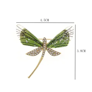 Close-up of the exquisite dragonfly brooch featuring green acrylic wings and sparkling rhinestones.